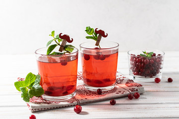 Fresh organic homemade cranberry lemonade with mint on white wooden background. Healthy vitamin drink.