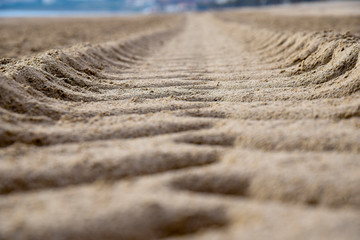 Fototapeta na wymiar marks in the sand Deep groove of heavy vehicle left on beach surface