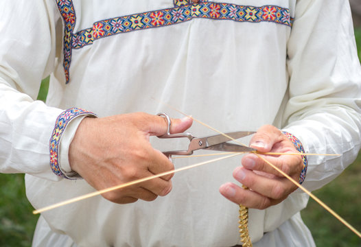 Old Man Hands With Scissors Cutting Of Linen Thread