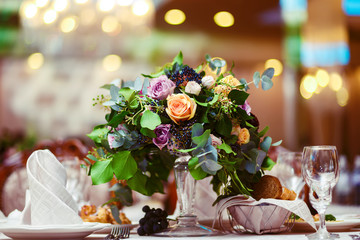 Beautiful flowers on table in wedding day. Decoration of wedding table with flowers. Beautiful wedding restaurant for marriage. Colorful decoration for celebration. Bouquet and flowers in hall.