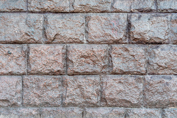 The texture of the massive wall of large gray stone. The basement of a large building.