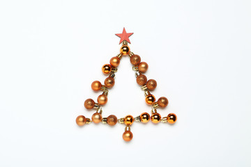 Flat lay christmas composition. Golden baubles in shape of fir tree on white background
