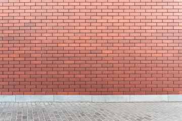 Wall red brick texture with an asphalt road. Urban style mockup background. Modern new brickwall on...