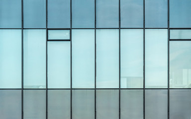Glass facade texture of a modern office building. High tech architecture. Elements of urban design. Reflections in the windows.