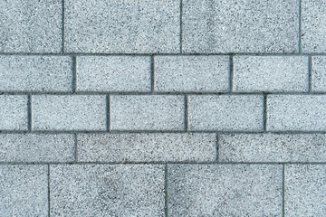 Texture of gray road concrete tiles. Background of sidewalk made of stone. Pavement of horizontal tiles.