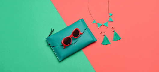Fashion party girl layout Flat lay. Minimal. Woman Essentials accessories. Trendy Clutch, sunglasses, earrings. Coloful pink green Set. Creative pop art concept, vibrant fashionable color