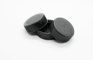 Βlack lids from plastic water bottles isolated on white background.