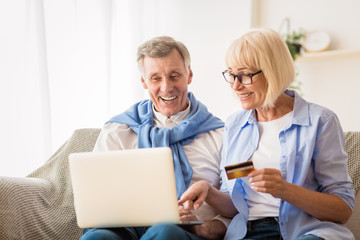 Fototapeta na wymiar Shopping online. Senior spouses making purchases on laptop