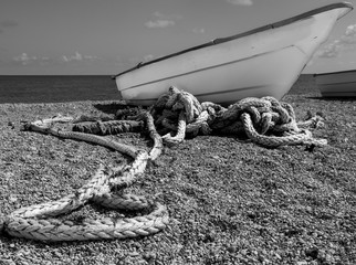 dramatic black and white image of a fishing boat and rope on the caribbean coast in dominican...