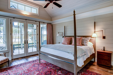 Beautiful luxury bedroom with view out onto waterfront and river. - obrazy, fototapety, plakaty
