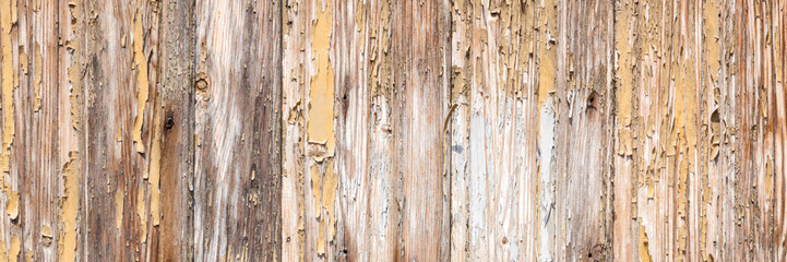 Background from a wall of boards with peeling off old paint. Copy space. Panoramic view.