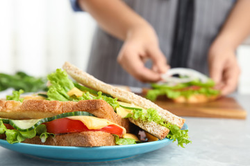 Tasty sandwiches on light grey marble table, closeup