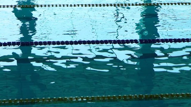 Empty pool with clear water and dividers track for swimming. Blue water in swimming pool