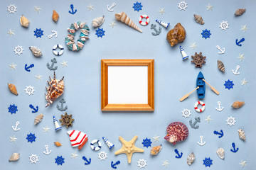Round frame made of decorative items and miniature toys: seashells, seastars, vessel, boat, anchors, steering wheels, life buoys. Empty wooden photoframe, mock-up. Summer vacation, sea travel concept