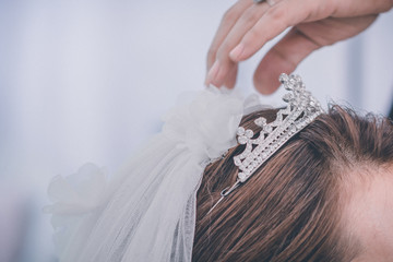 bride dress wear a crown on her head is a picture taken at the wedding.