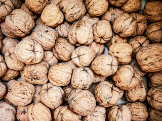 A lot of walnuts, relief, closed, in a shell (background, pattern) from a close distance