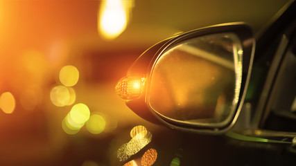 bright bokeh light from headlamps car at night city street in traffic jam, side mirror close-up