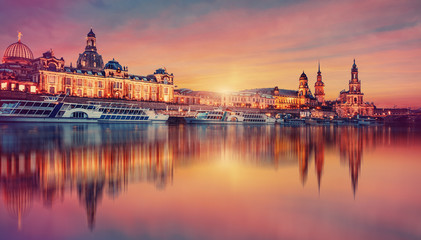 Awesome colorful scene during sunset  at the Old Town in Dresden, Saxony, Germany. Famouse Sights: Frauenkirche, Hofkirche, Semperoper with reflected in calm water  Elbe river. picturesque scenery.