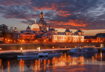 Fototapeta na wymiar Colorful sunset with colorful dramatic sky, over the famouse Old Town architecture in Dresden reflected in water. Scenic sunset view of ancient buildings in Dresden, Bavaria, Germany. Creative image