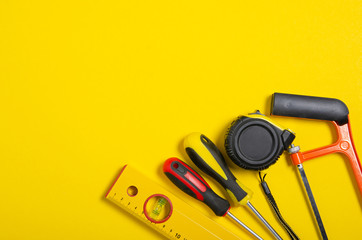 Work hand tools on yellow background. Top view composition.