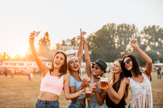 Female friends having fun and taking selfie at music festival