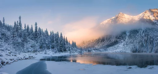 Poster Zonsopgang in de winterbergen. Berg weerspiegeld in ijsmeer in de ochtendzon. Geweldig panoramisch natuurlandschap in de bergvallei. © dzmitrock87