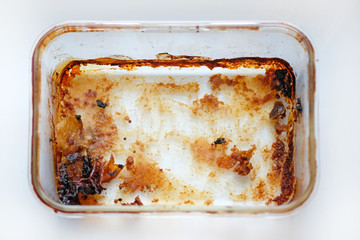Rectangular glass baking dish top view. Dirty meat baking dish. An empty tray made of heat...