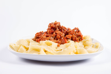 Reginette pasta with bolognese sauce on a plate on a white background