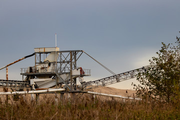 Fototapeta na wymiar Sand dredger with mounds of sand in background