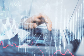 Double exposure of market chart with man working on computer on background. Concept of financial analysis.