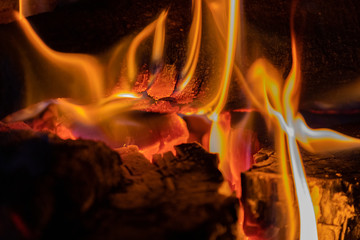 Burning coal and logs with flames in fireplace