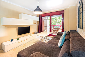 Modern interior decoration of a living room with a sofa, retro lamp, marble floor, vintage watch, mirrow, minimal furniture and a terrace.