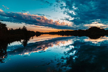 Beautiful sunset with arrow-shaped reflections near Plattling, Isar, Bavaria, Germany