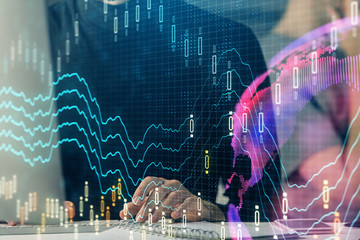 Forex graph with businessman typing on computer in office on background. Concept of analysis. Double exposure.