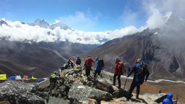 Climbers at the top, Nepals flags fluttering in the wind. Mount Taboche and Mount Cholatse in the Himalayas, view from top of Nangartsang peak, view of the valley of souls in Himalaya, Nepal