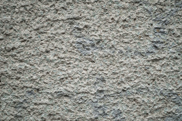 Surface texture of gray stone hewn wall.