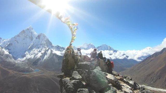 Climbers at the top, the sun shines, Nepals flags fluttering in the wind. Ama Dablam mountain in the Himalayas, view from top of Nangartsang peak. Himalaya, Nepal