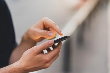 Close-up of male hands pointing finger on screen smart phone, City vibe concept