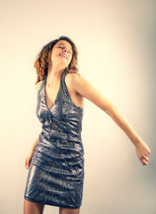 Young young woman in silver dress laughing and having fun