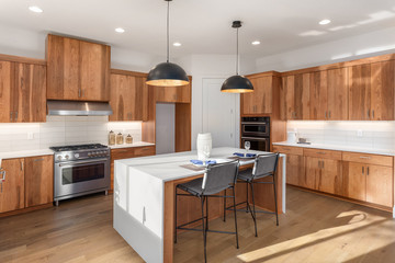 Beautiful kitchen in new luxury home with waterfall island, quartz counter tops, farmhouse sink,...