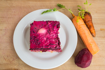 Dressed herring or herring under a fur coat. Traditional Russian cuisine. Layered salad composed of diced pickled herring covered with layers of boiled grated vegetables and mayonnaise.