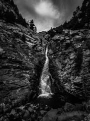 Cascada en las montañas. Fotografia vertical en blanco y negro