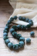 Wool jewelry against the background of a pullover or sweater, felting.