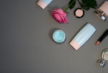 Flat lay image of make up products on gray background