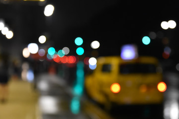 Concept of street and taxi blurred at night with bokeh of lights. NYC, USA