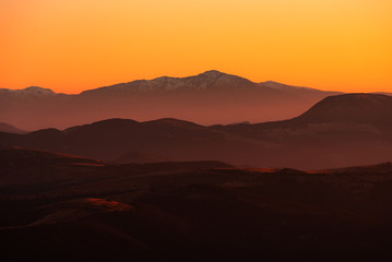 Sunset mountain peaks covered with snow . Carpathians mountain peaks sunset view. Sunset  mountain peaks silhouette.
