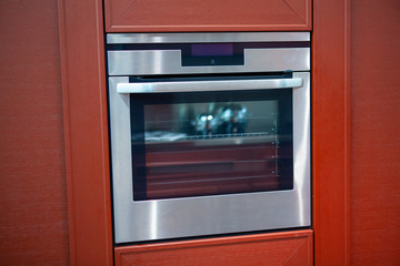Electric oven integrated in the modern red kitchen