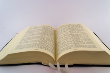 Obraz premium Books and pages against white background. Holly Bible and Davids psalms. Close up words and letters