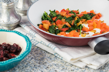 Cooked spinach quinoa brown rice with vegetables and berries.