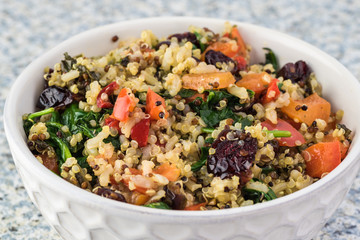 Cooked spinach quinoa brown rice with vegetables and berries. - obrazy, fototapety, plakaty